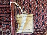 an old rug with a tag on it sitting on top of it