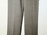 grey pants hanging on a hanger against a white wall