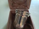 une coupe en argent dans un coffret en bois posé sur une table