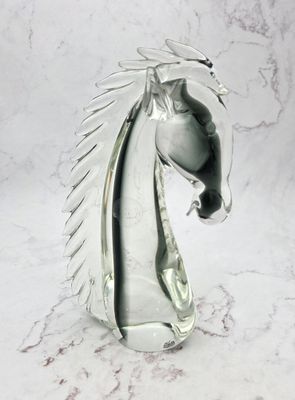 une tête de cheval en verre posée sur un plan de travail en marbre