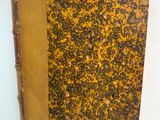 un vieux livre à la couverture brune posé sur une table