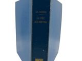an old blue book sitting on top of a white surface