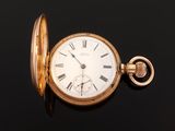 an antique pocket watch with roman numerals on a black surface