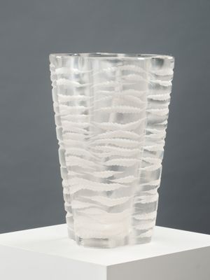 a glass vase that is sitting on a white pedestal