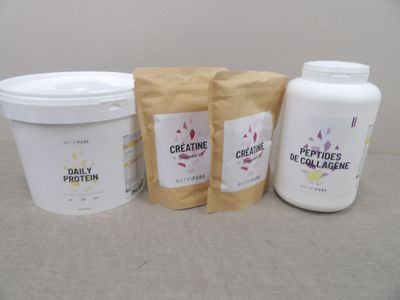 trois sachets de créatine à côté d'un pot de créatine