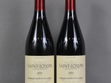 deux bouteilles de vin rouge sont posées sur une table en verre