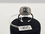un gros plan d'une bague en argent sertie d'une pierre noire