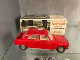 a red toy car sitting on a glass shelf next to a box