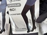 many pairs of black tights on display in a store