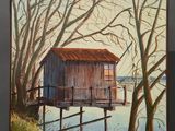 an oil painting of a house on a wooden easel by a body of water
