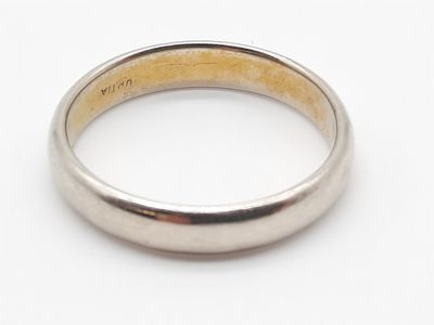 gros plan d'une bague en argent sur une surface blanche