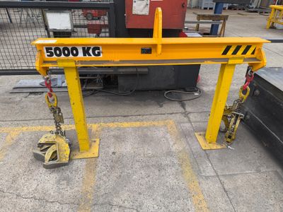 a crane that is sitting on the ground in front of a fence
