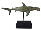 une photo d'une statue représentant un requin posée sur un socle noir