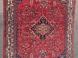 an oriental rug hanging on a wall in a room
