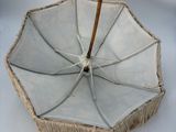 a white umbrella with a wooden handle on a white surface