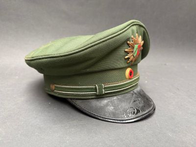 a green hat with a flower on it sitting on a table