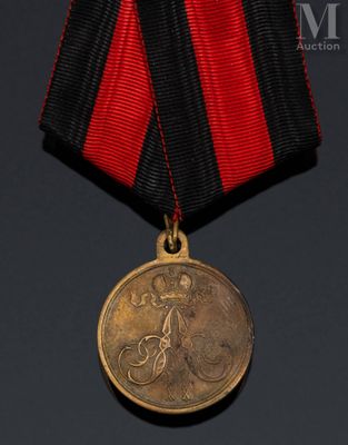 une vieille médaille à laquelle est accroché un ruban rouge et noir autour du cou