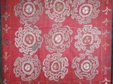 un vieux tissu brodé rouge et blanc orné de motifs floraux
