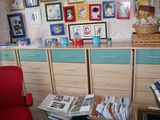 a red chair sitting in front of a desk in a room with pictures on the wall