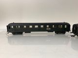 two black train cars sitting side by side on a white surface