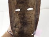 a person holding a wooden mask on a white surface
