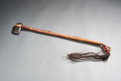 une vieille hache avec un long cheveu posé sur une table