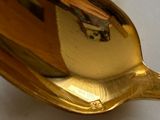 a gold spoon that is sitting on a white table