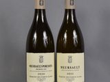two bottles of wine sitting on top of a table next to each other