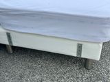 a white bed with a white sheet on top of it