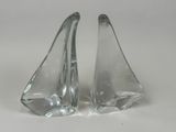 paire de salières et poivrières en forme de voiliers en verre transparent sur fond blanc