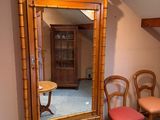 a mirror in the corner of a room with chairs and a table