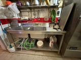 a stainless steel sink in a kitchen with pots and pans on the wall