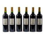 four bottles of wine are lined up on a white surface