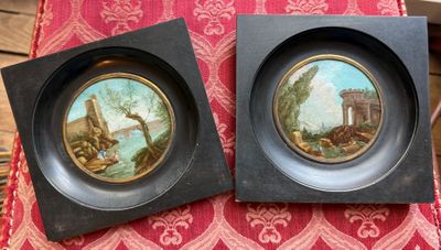 deux tableaux encadrés représentant un paysage et un château sur un fond rouge et or