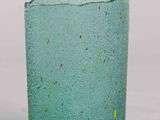 a green glass vase with a yellow speckle on it