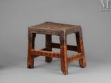 an old wooden stool sitting on top of a gray surface