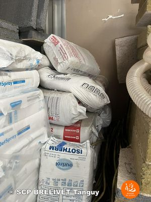 a cat that is sitting on the floor next to a pile of bags