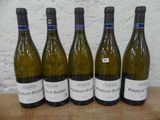 Six bouteilles de vin blanc sont alignées sur une table en bois.