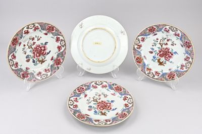 trois assiettes et un bol décorés de fleurs, posés sur une table