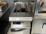un réchaud en argent équipé d'une friteuse et contenant de la nourriture