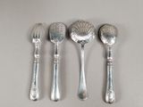 four spoons and two spoons sitting on a table