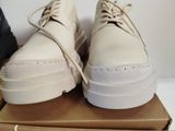 pair of white shoes sitting on top of a box on top of a table