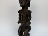 une statue en bois représentant une femme tenant un bébé dans ses bras