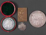 an assortment of silver and silver coins including a medal, a medal, and a medal