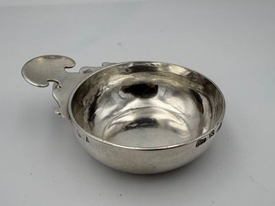 un bol en argent avec une cuillère sur une table
