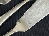 two forks and a knife on a black table