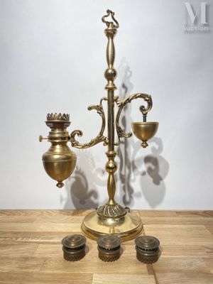 un candélabre ancien en laiton à trois bougies posé sur une table en bois
