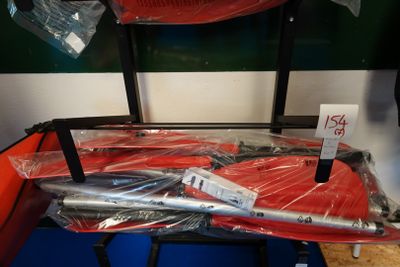 beaucoup de parapluies rouges emballés dans du plastique, posés sur un tapis bleu