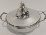 une casserole en argent avec un couvercle, posée sur une table blanche