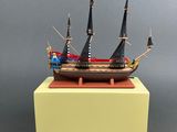 a small model of a wooden ship on a yellow stand